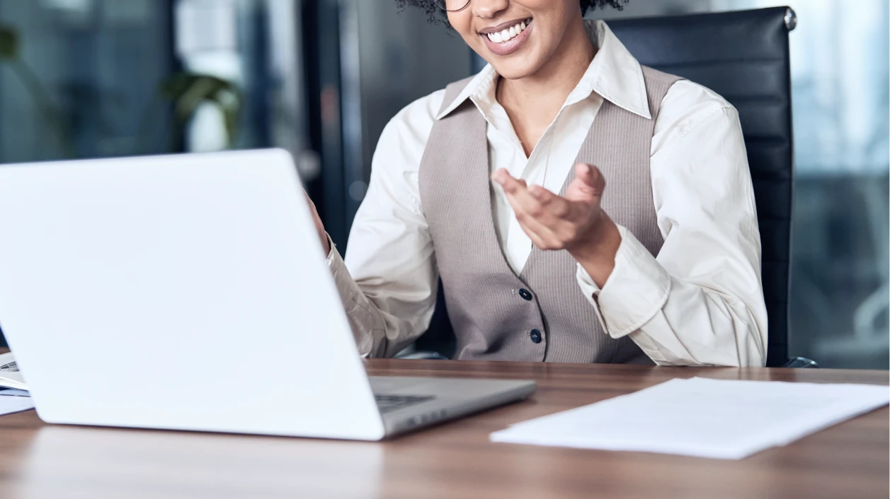 笑顔でラップトップを見ながら説明する女性のビジネスパーソン