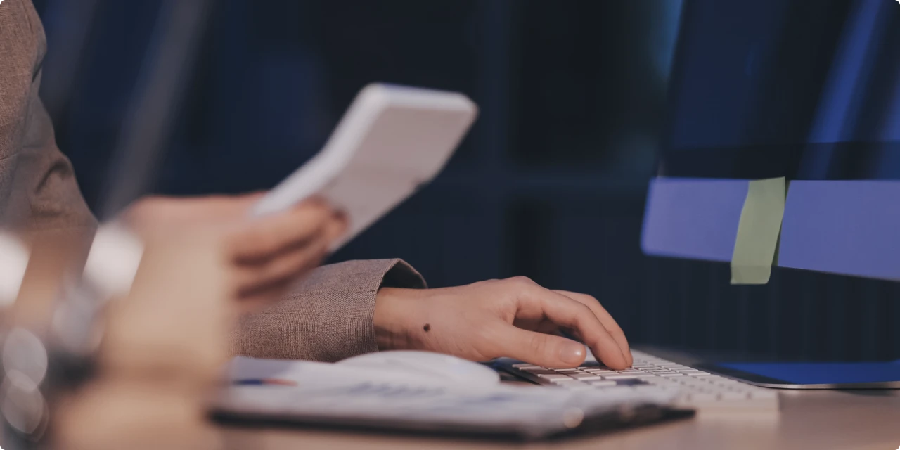 資料を見ながらキーボードを操作する手元