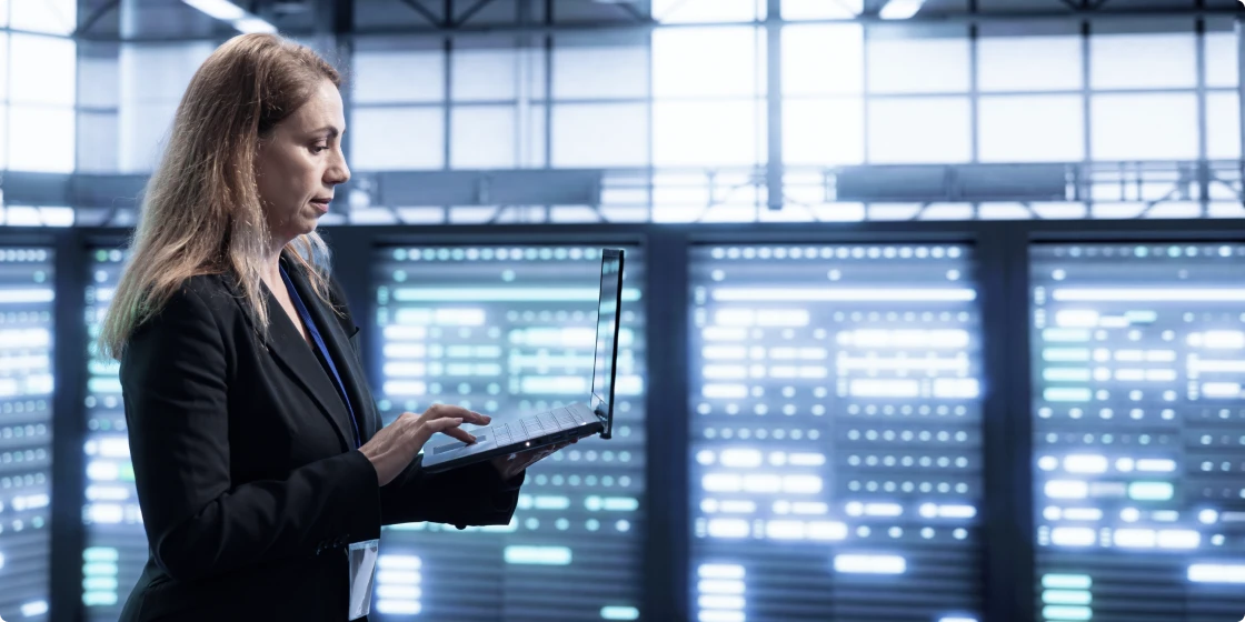 データセンターでノートパソコンを操作する女性エンジニア